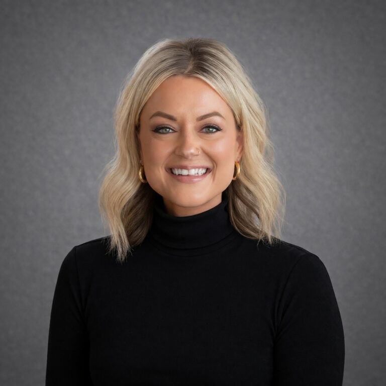 Headshot of Kayla Brown smiling in a black turtleneck against a gray studio background