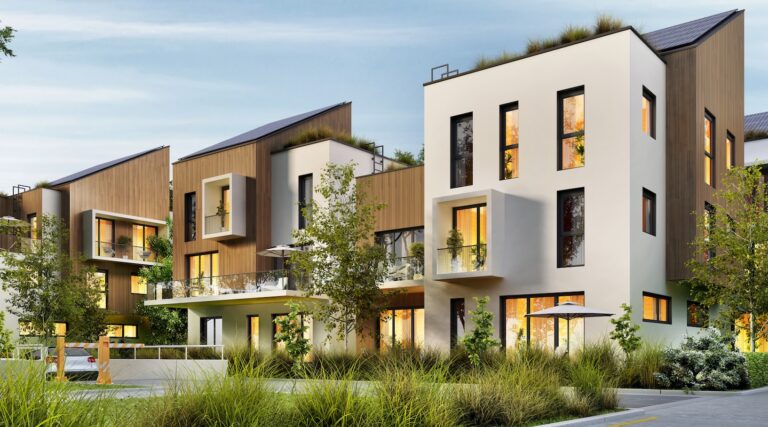 Modern multi-story apartment buildings with wood and white facades, balconies, and landscaped trees at dusk